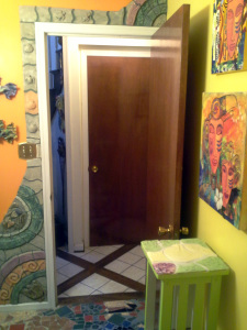 the picture is odd - you are looking our the bathroom door to the hall (tile and wood) and basement door.  Around the bathroom door is one of the first architectural tiles work that I made after learning how.